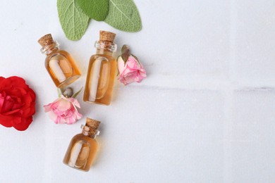 Photo of Bottles of cosmetic products, roses and sage on white table, flat lay. Space for text