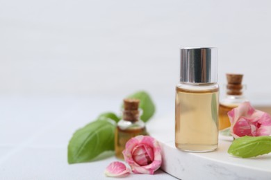 Photo of Bottles of cosmetic products, roses and basil on white table, closeup. Space for text