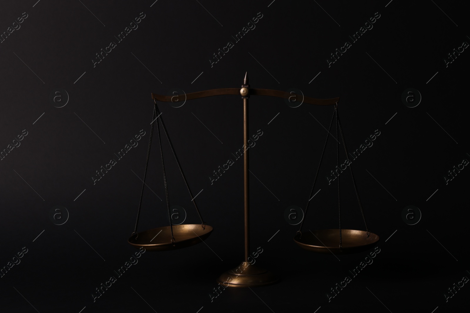 Photo of Golden scales of justice on black background