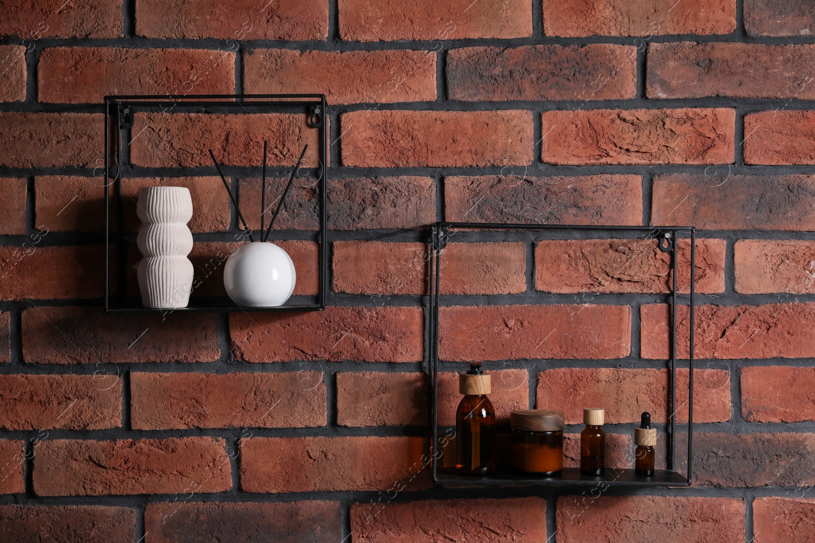 Photo of Square shaped shelves with cosmetic product and home decor on brick wall