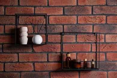 Photo of Square shaped shelves with cosmetic product and home decor on brick wall