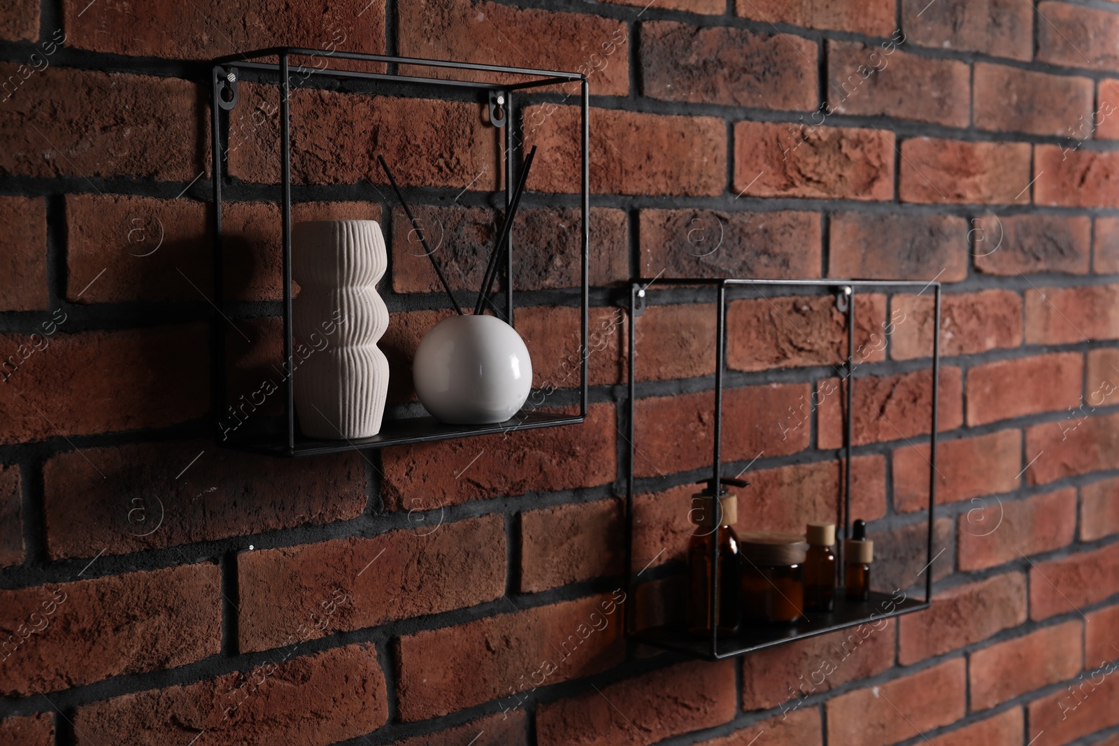 Photo of Square shaped shelves with cosmetic product and home decor on brick wall