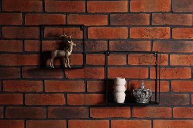 Photo of Square shaped shelves with home decor on brick wall