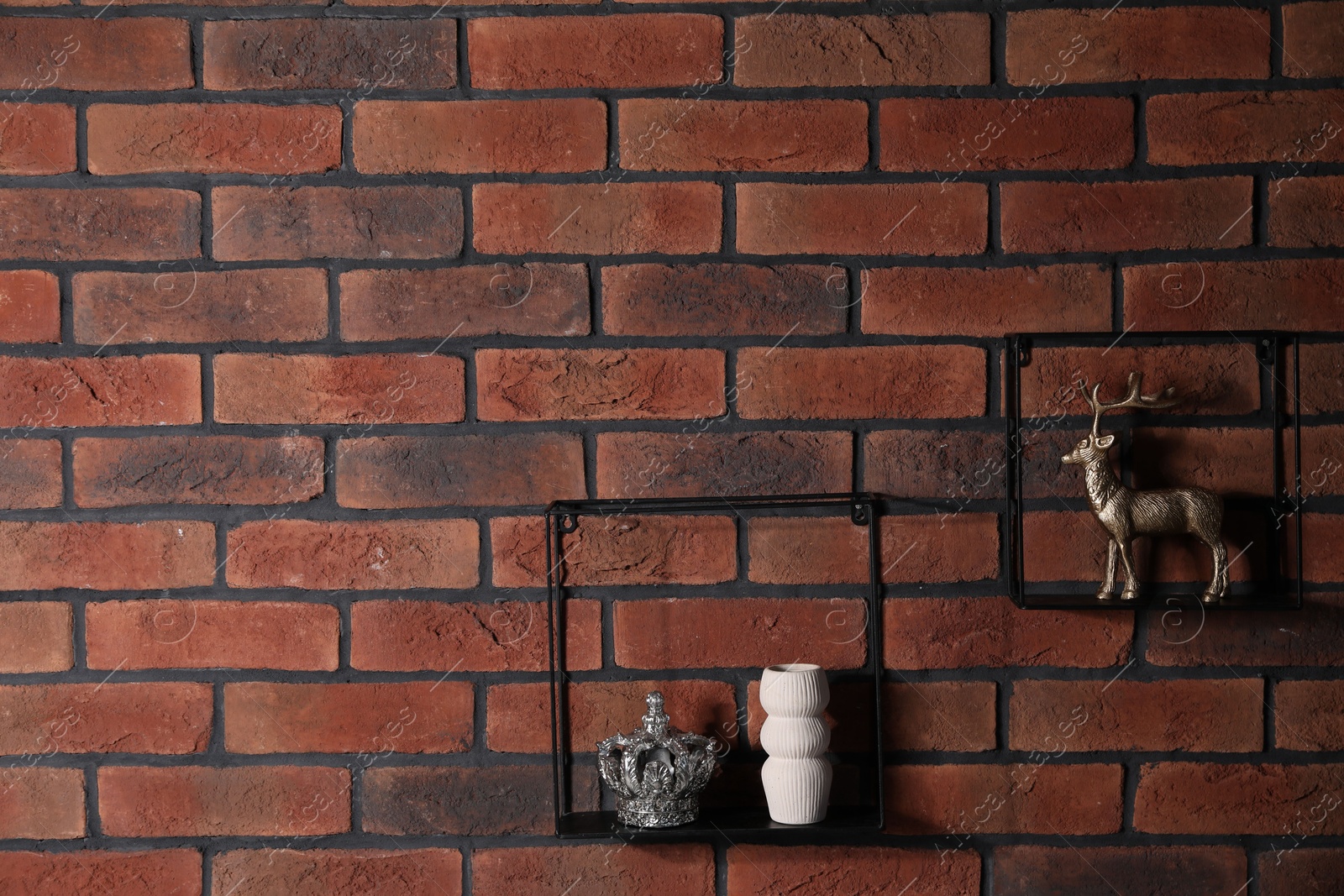 Photo of Square shaped shelves with home decor on brick wall, space for text