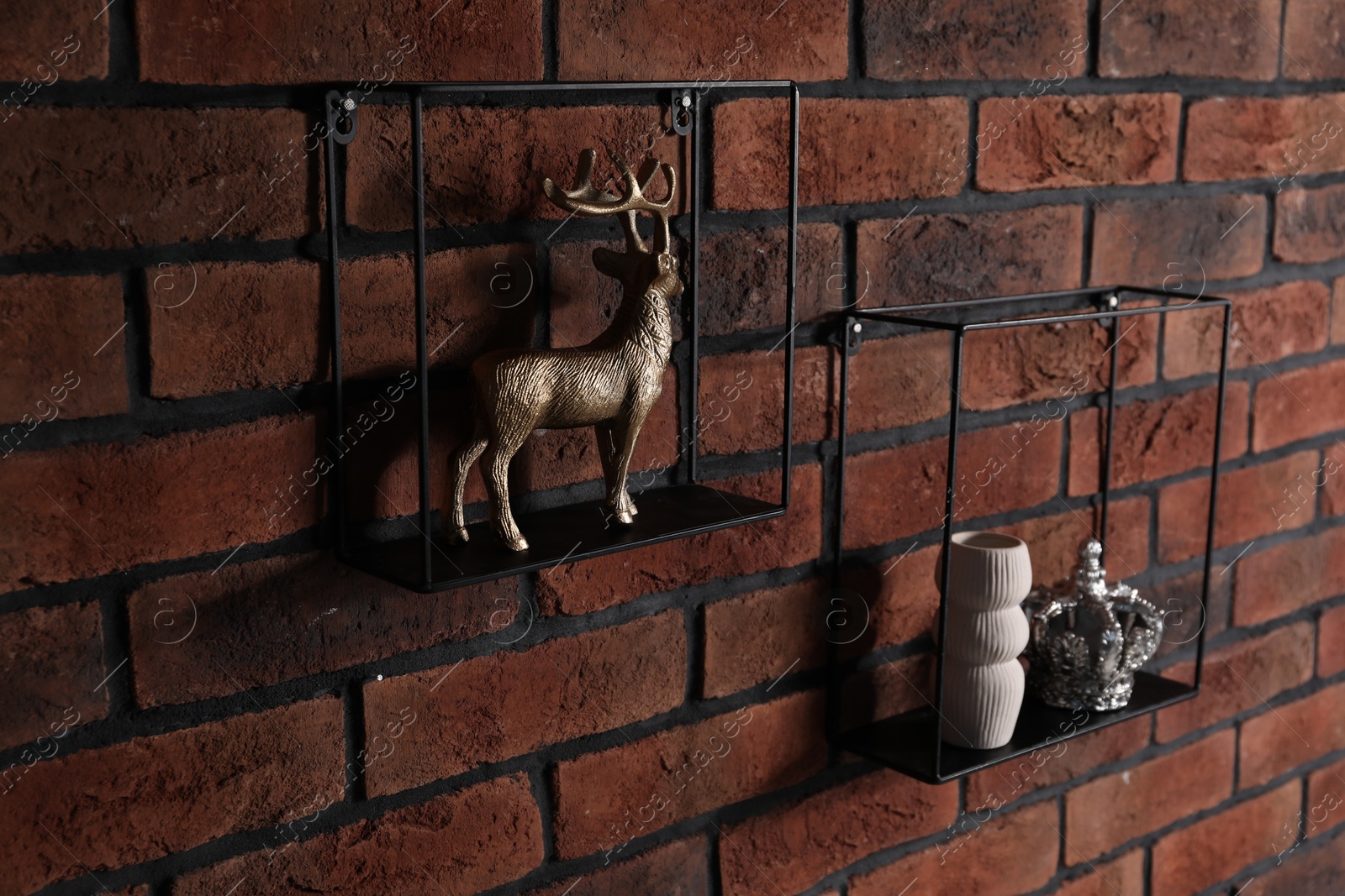 Photo of Square shaped shelves with home decor on brick wall