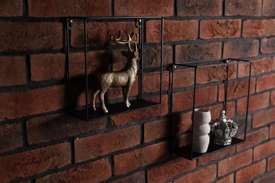 Photo of Square shaped shelves with home decor on brick wall