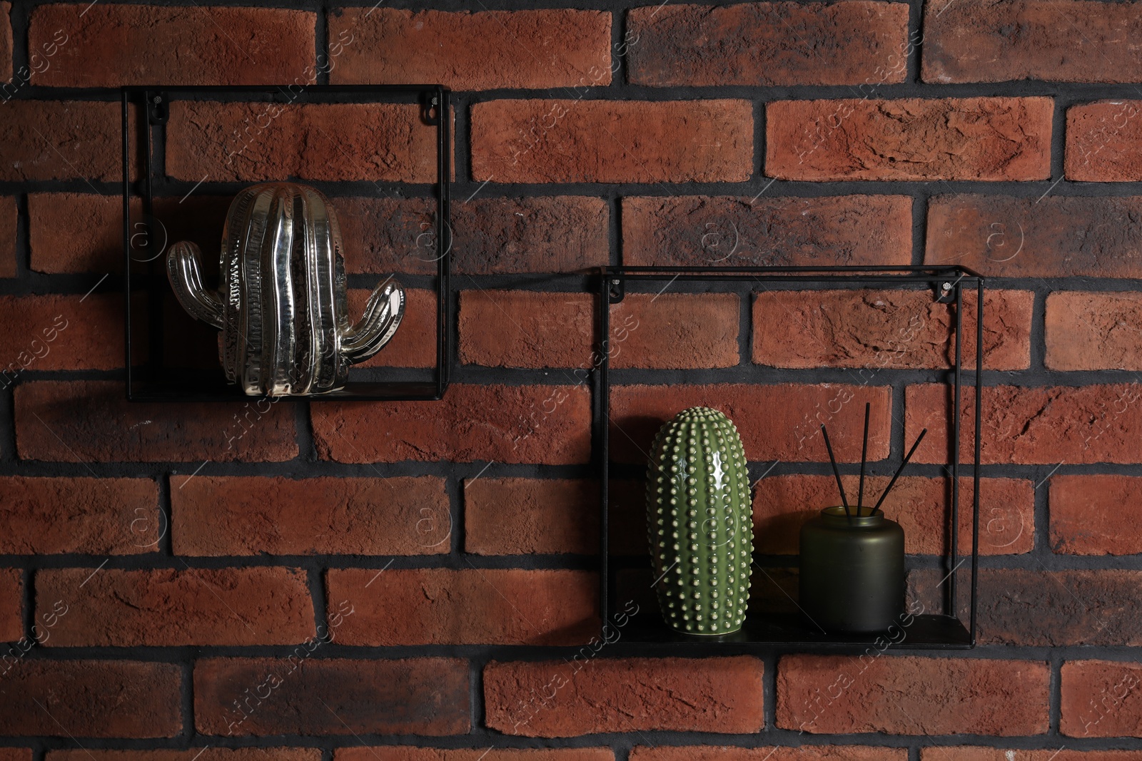 Photo of Square shaped shelves with home decor on brick wall
