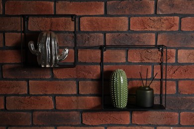 Photo of Square shaped shelves with home decor on brick wall