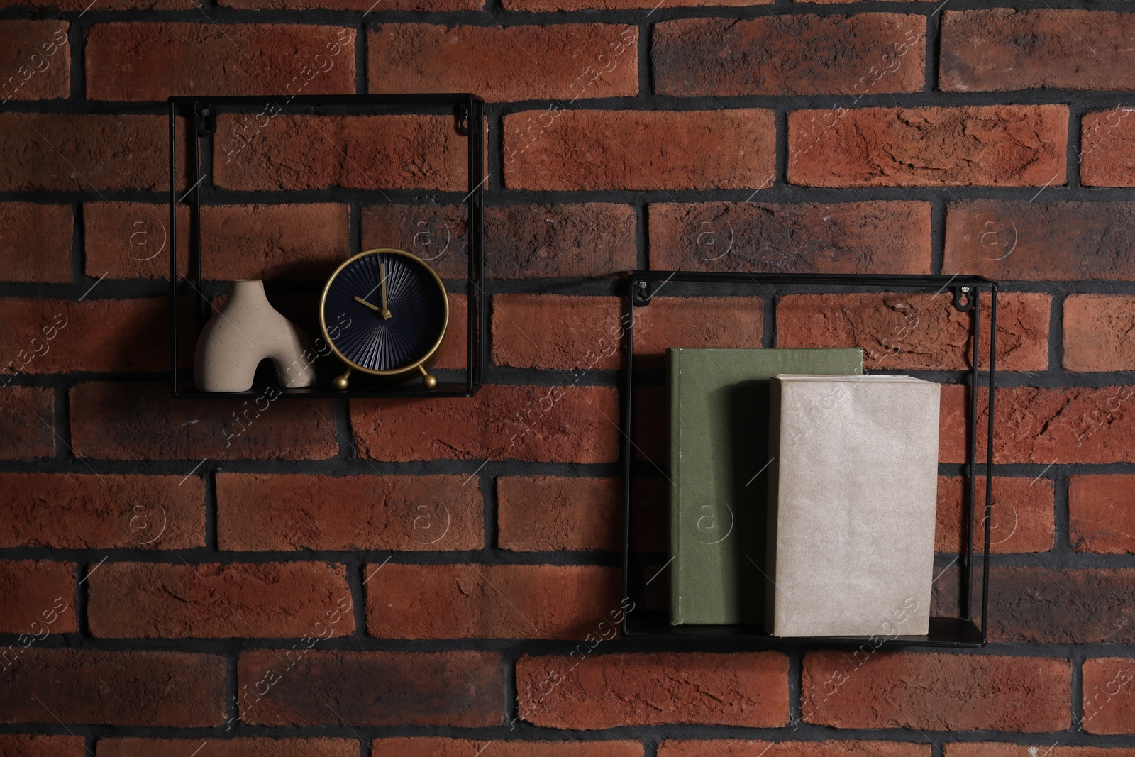 Photo of Square shaped shelves with books and home decor on brick wall