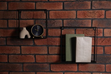 Photo of Square shaped shelves with books and home decor on brick wall