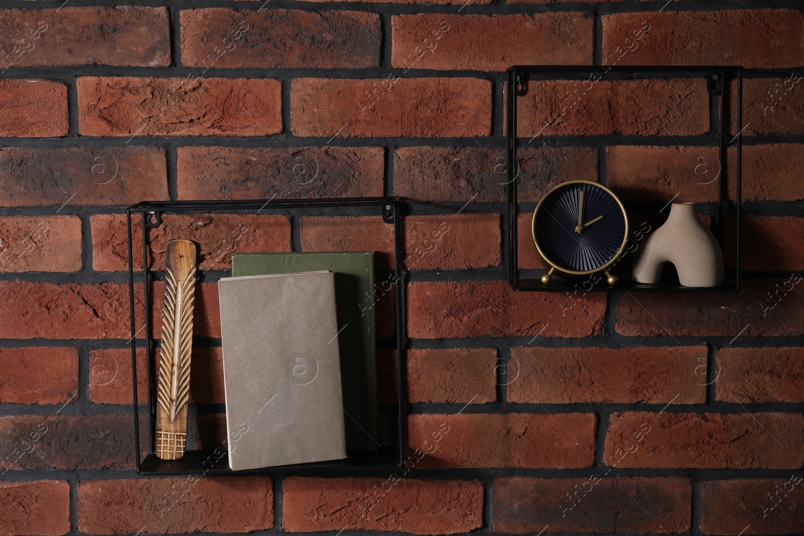 Photo of Square shaped shelves with books and home decor on brick wall