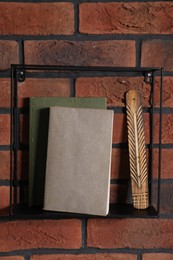 Photo of Square shaped shelf with books and home decor on brick wall