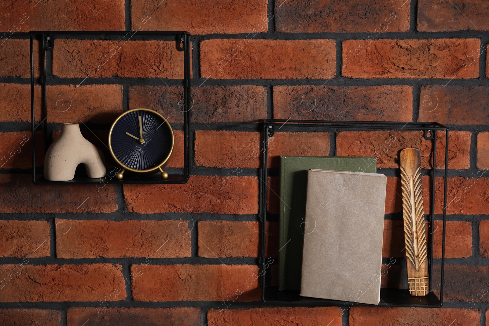 Photo of Square shaped shelves with books and home decor on brick wall