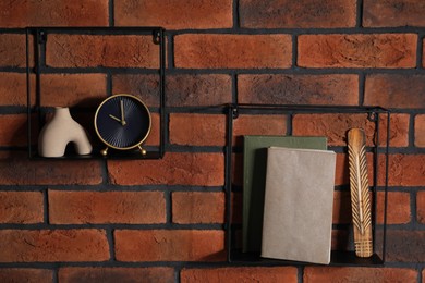 Photo of Square shaped shelves with books and home decor on brick wall