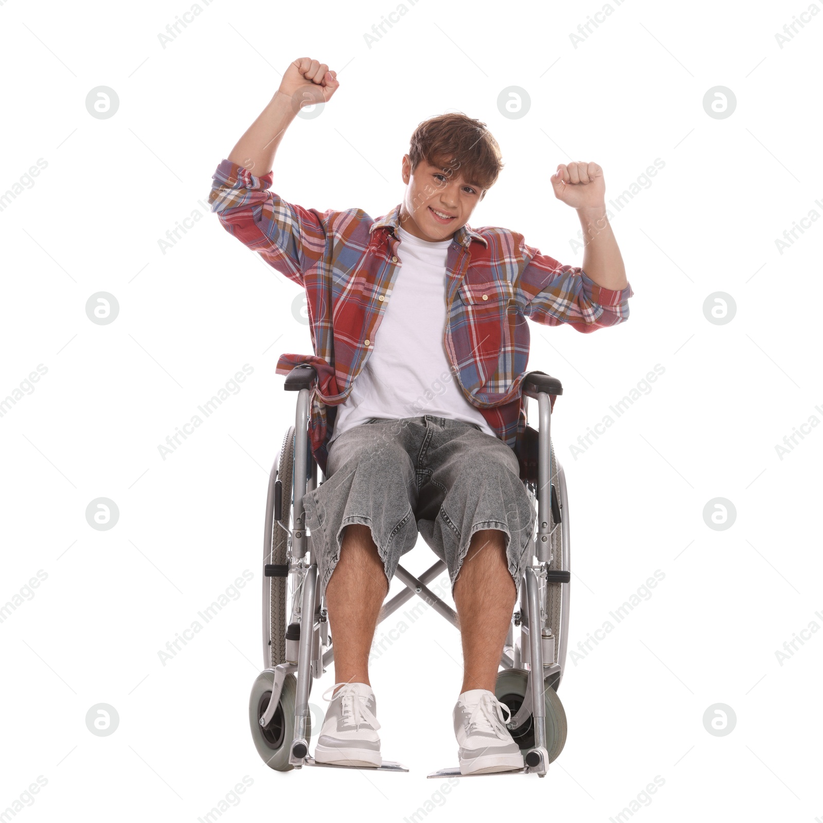 Photo of Smiling teenage boy in wheelchair on white background