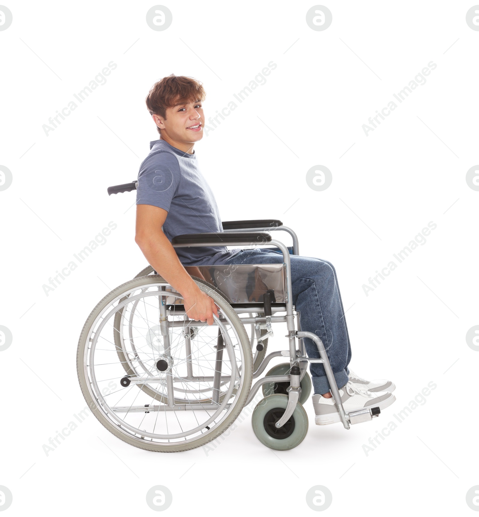 Photo of Smiling teenage boy in wheelchair on white background