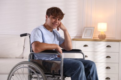 Photo of Smiling teenage boy in wheelchair at home