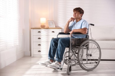 Photo of Smiling teenage boy in wheelchair at home