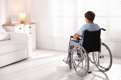 Photo of Teenage boy in wheelchair in light room