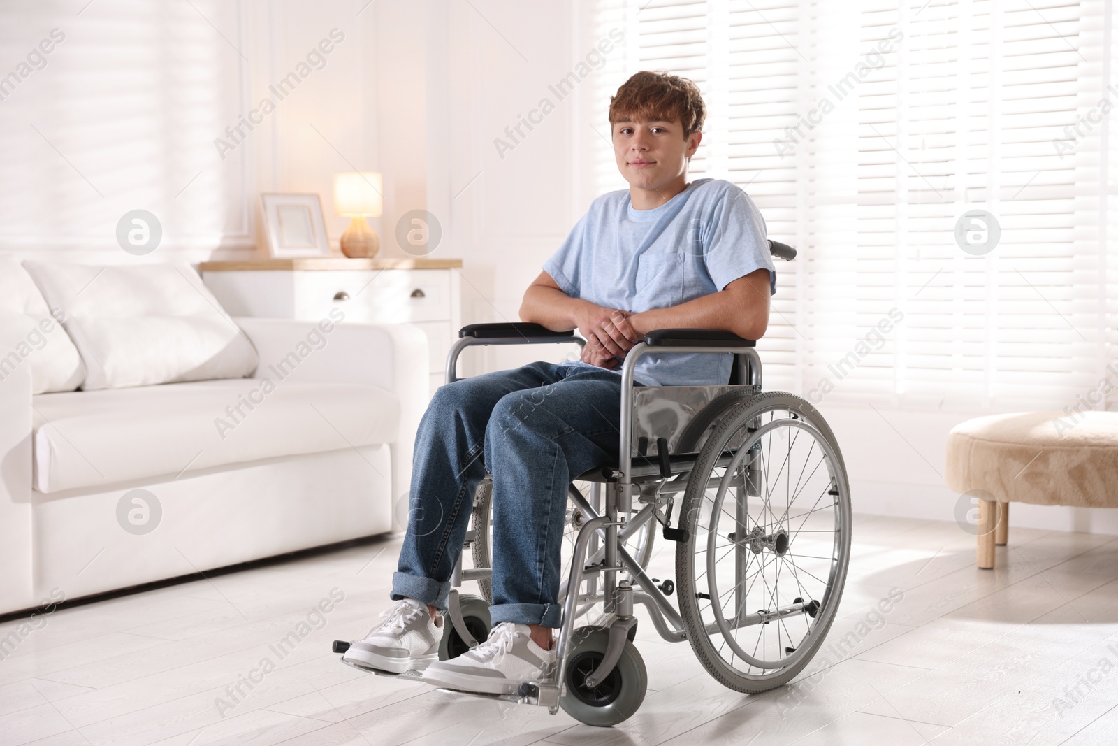 Photo of Teenage boy in wheelchair in light room