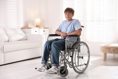 Photo of Teenage boy in wheelchair in light room