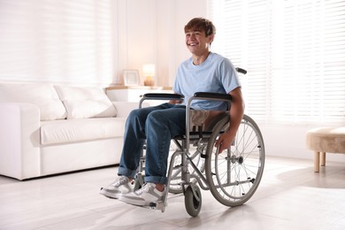 Photo of Smiling teenage boy in wheelchair at home