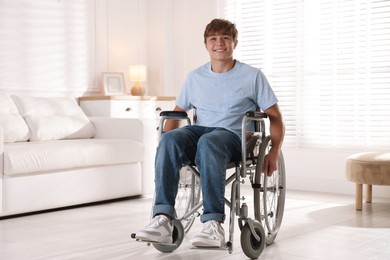 Photo of Smiling teenage boy in wheelchair at home