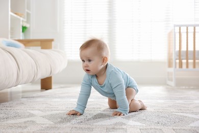 Photo of Cute little baby crawling on floor at home