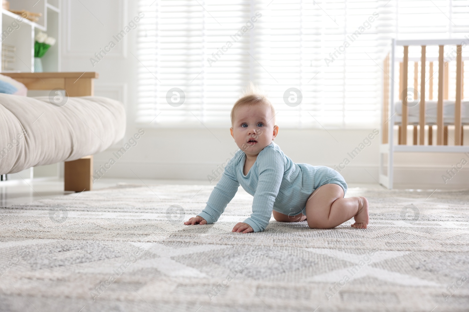 Cute little baby crawling on floor at home Photo of Cute little baby crawling on floor at home