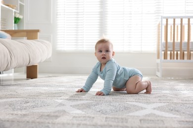 Photo of Cute little baby crawling on floor at home