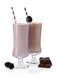 Photo of Different tasty milkshakes in glasses and ingredients isolated on white