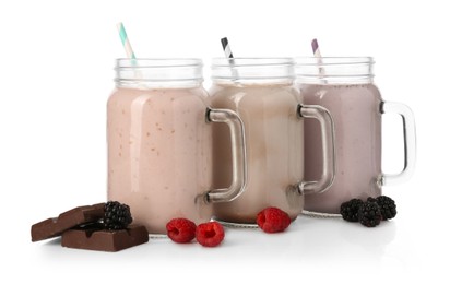Photo of Different tasty milkshakes in mason jars and ingredients isolated on white