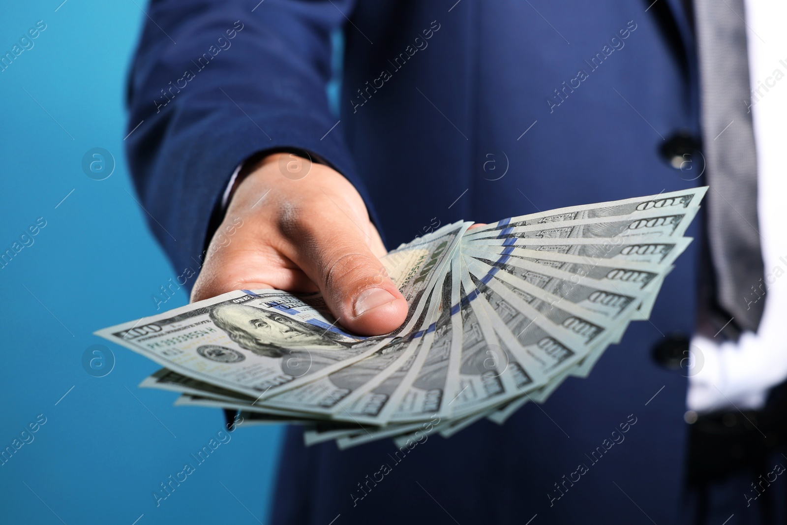 Man with dollar bills on blue background, closeup Photo of Man with dollar bills on blue background, closeup