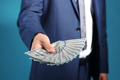 Photo of Man with dollar bills on blue background, closeup