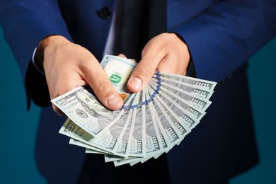 Photo of Man with dollar bills on blue background, closeup