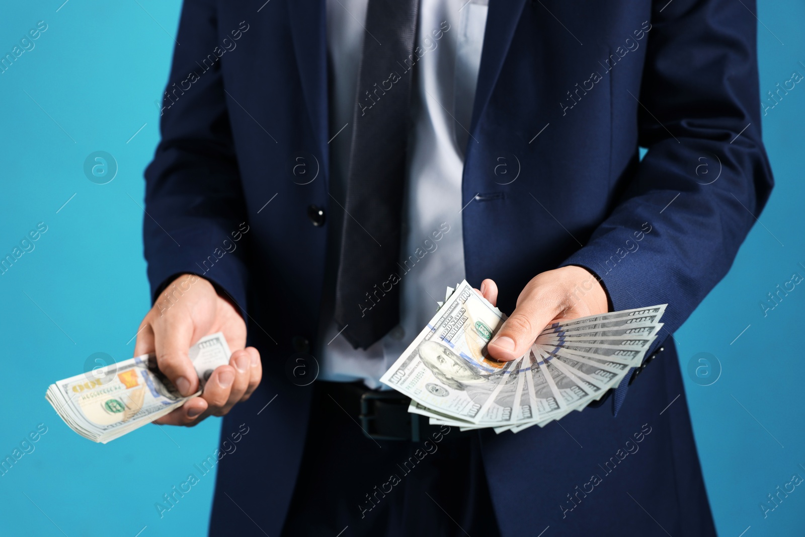 Man with dollar bills on blue background, closeup Photo of Man with dollar bills on blue background, closeup