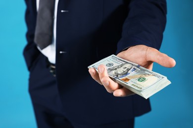 Photo of Man with dollar bills on blue background, closeup