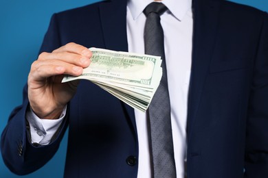 Photo of Man with dollar bills on blue background, closeup