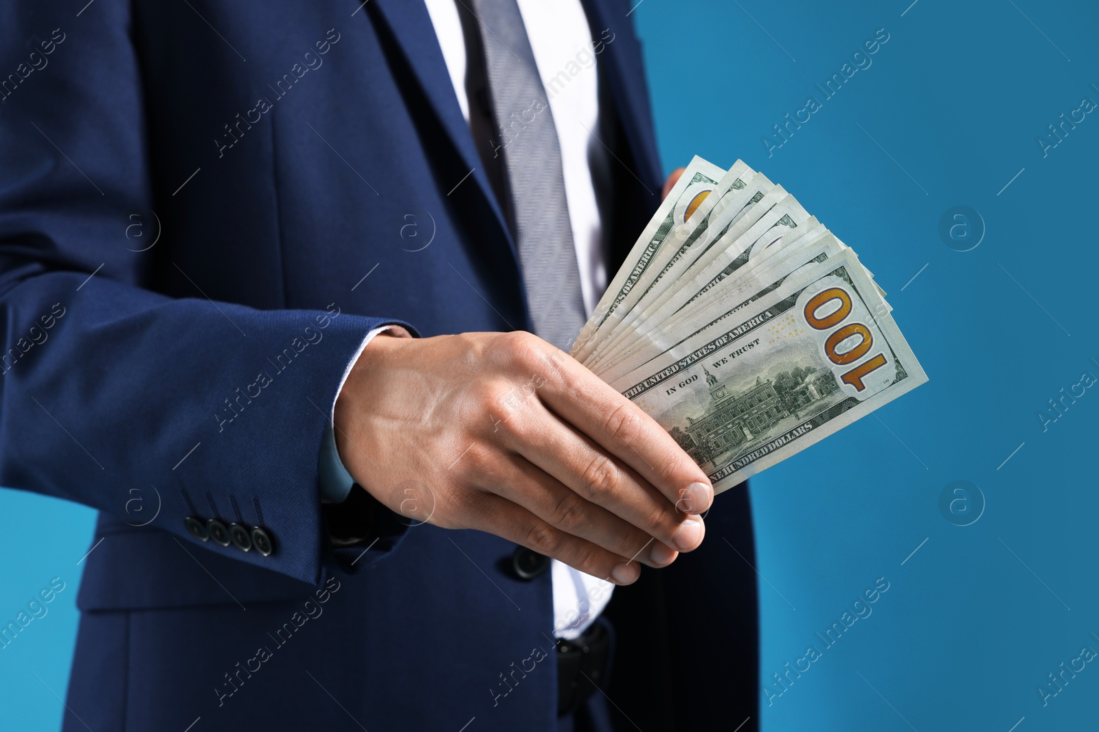 Man with dollar bills on blue background, closeup Photo of Man with dollar bills on blue background, closeup