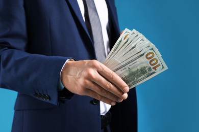 Photo of Man with dollar bills on blue background, closeup