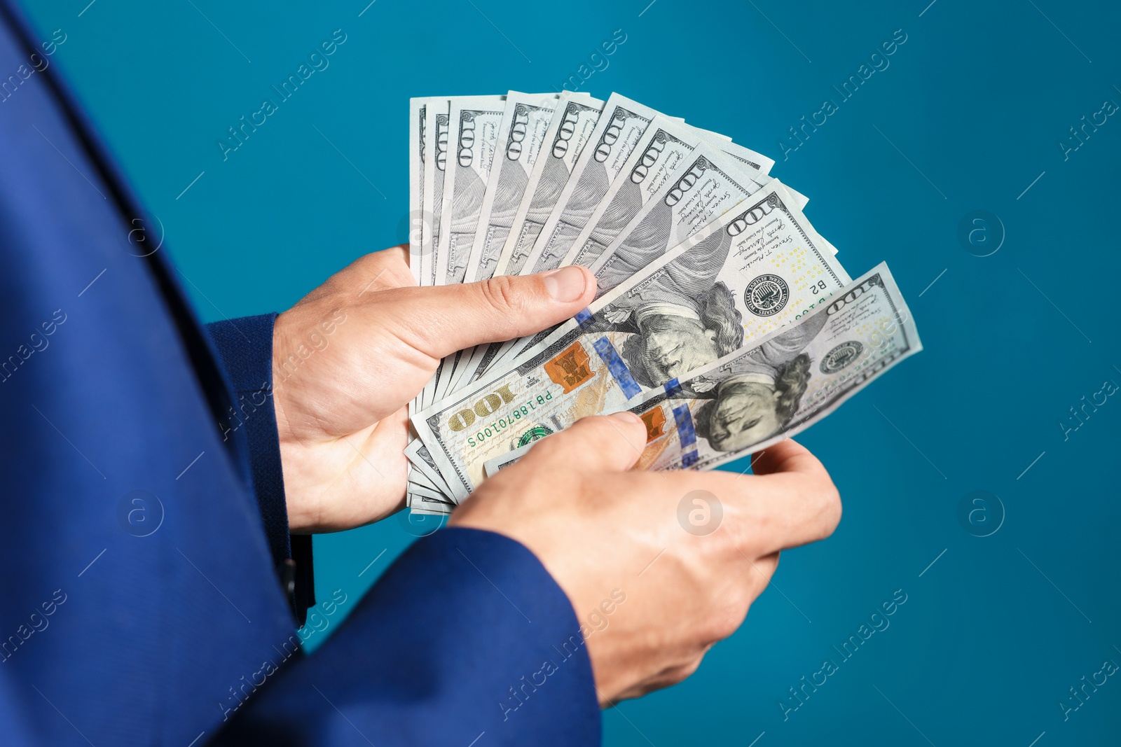 Man with dollar bills on blue background, closeup Photo of Man with dollar bills on blue background, closeup