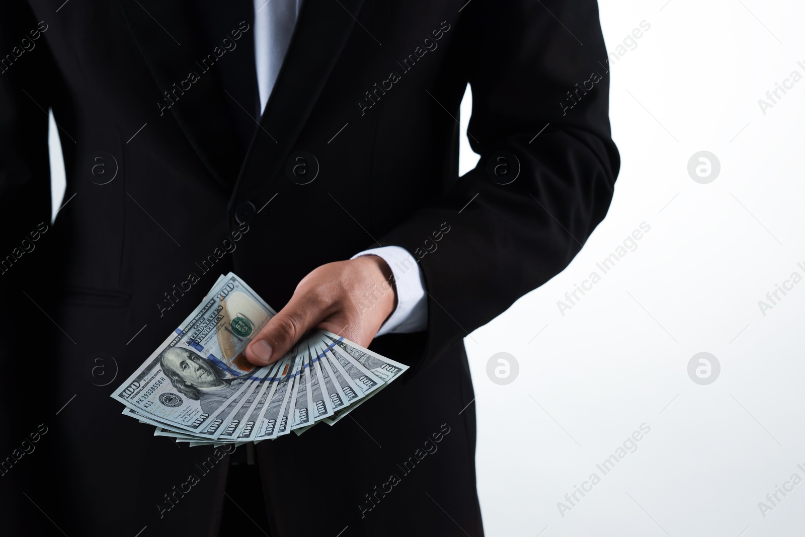 Man with dollar bills on light background, closeup Photo of Man with dollar bills on light background, closeup