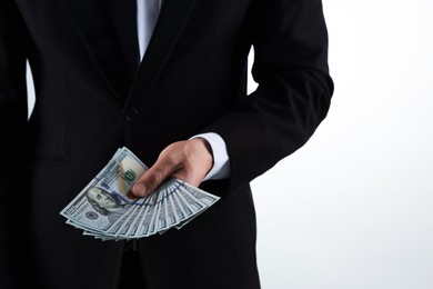 Photo of Man with dollar bills on light background, closeup