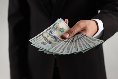 Photo of Man with dollar bills on light background, closeup