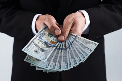 Photo of Man with dollar bills on light background, closeup