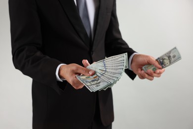 Photo of Man with dollar bills on light background, closeup