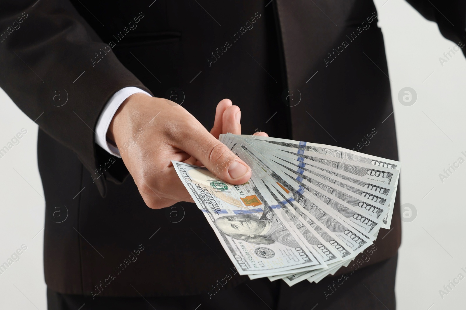 Man with dollar bills on light background, closeup Photo of Man with dollar bills on light background, closeup