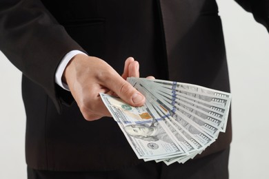 Photo of Man with dollar bills on light background, closeup