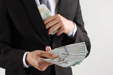 Photo of Man with dollar bills on light background, closeup