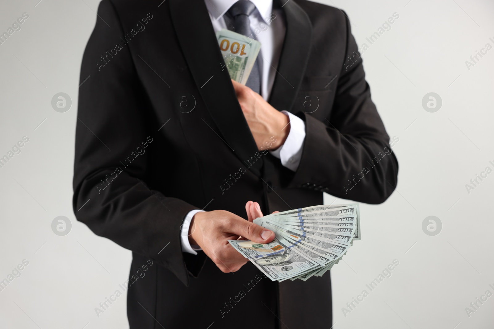 Man with dollar bills on light background, closeup Photo of Man with dollar bills on light background, closeup